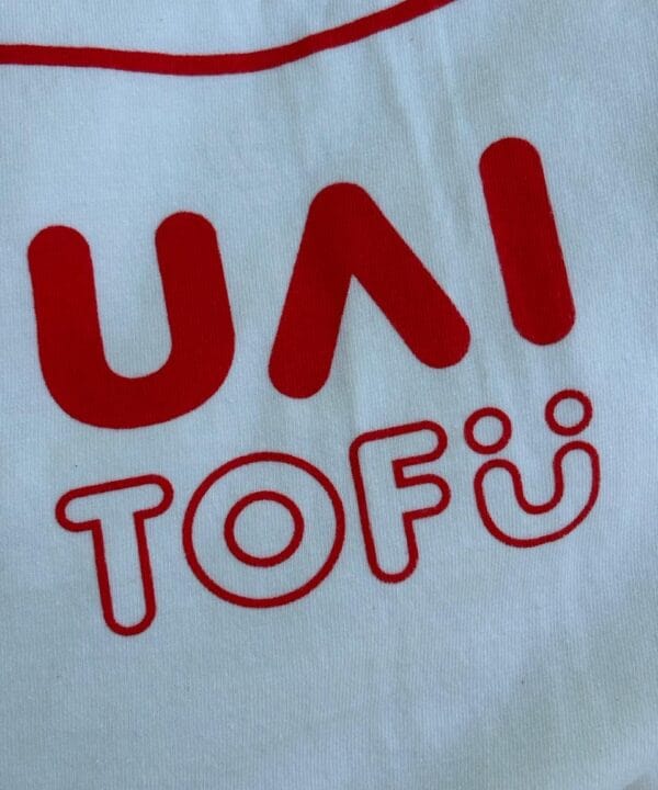 Alta expressão de tofu UAI com destaque em camiseta branca vermelha.