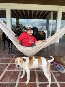 1. Cabra, cachorro e pessoa relaxando em ambiente ao ar livre, mundo pet e agroecologia.